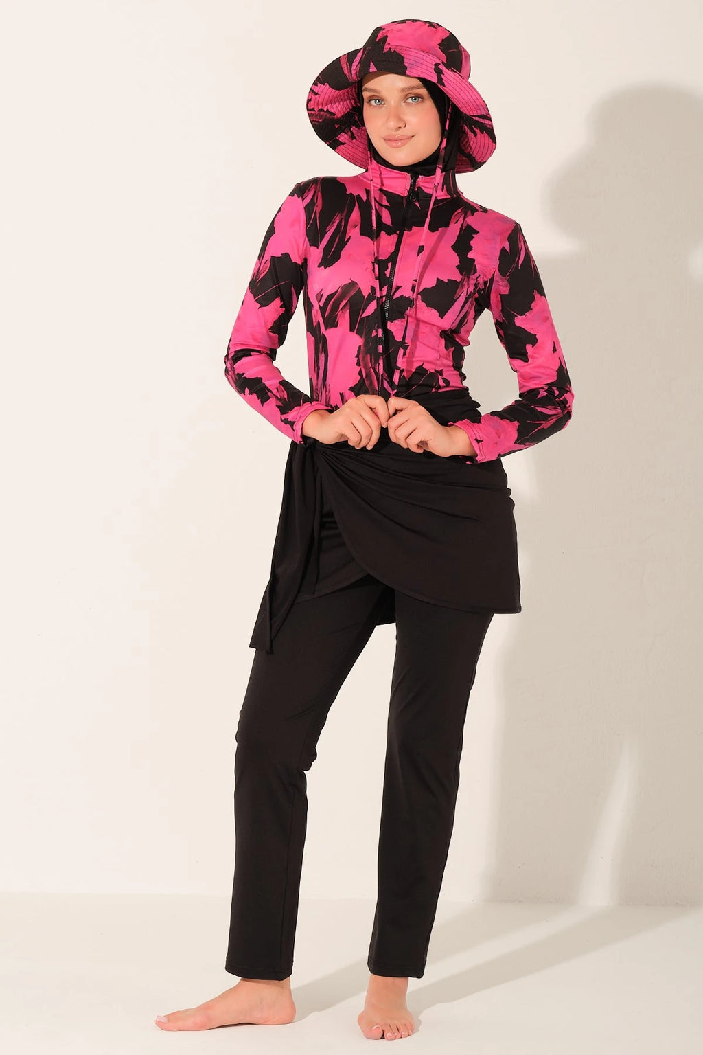 Woman in active floral burkini set, adjusting sarong.