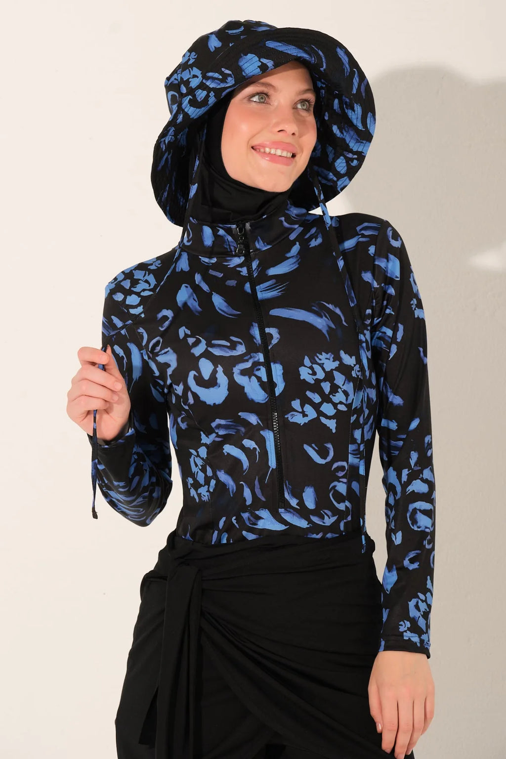 Model in midnight bloom burkini set, close-up smiling, holding drawstring.