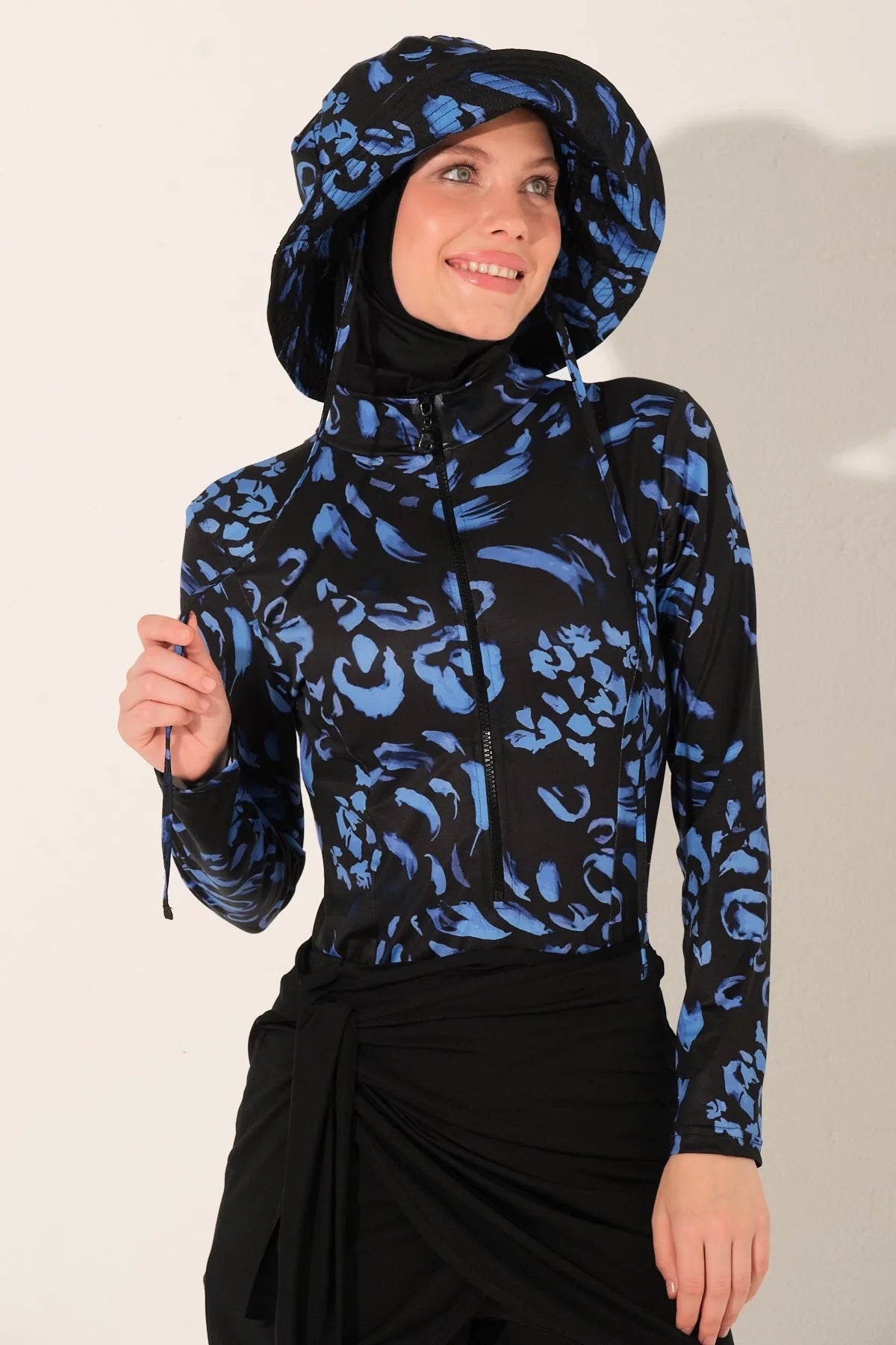 Model in midnight bloom burkini set, close-up smiling, holding drawstring.