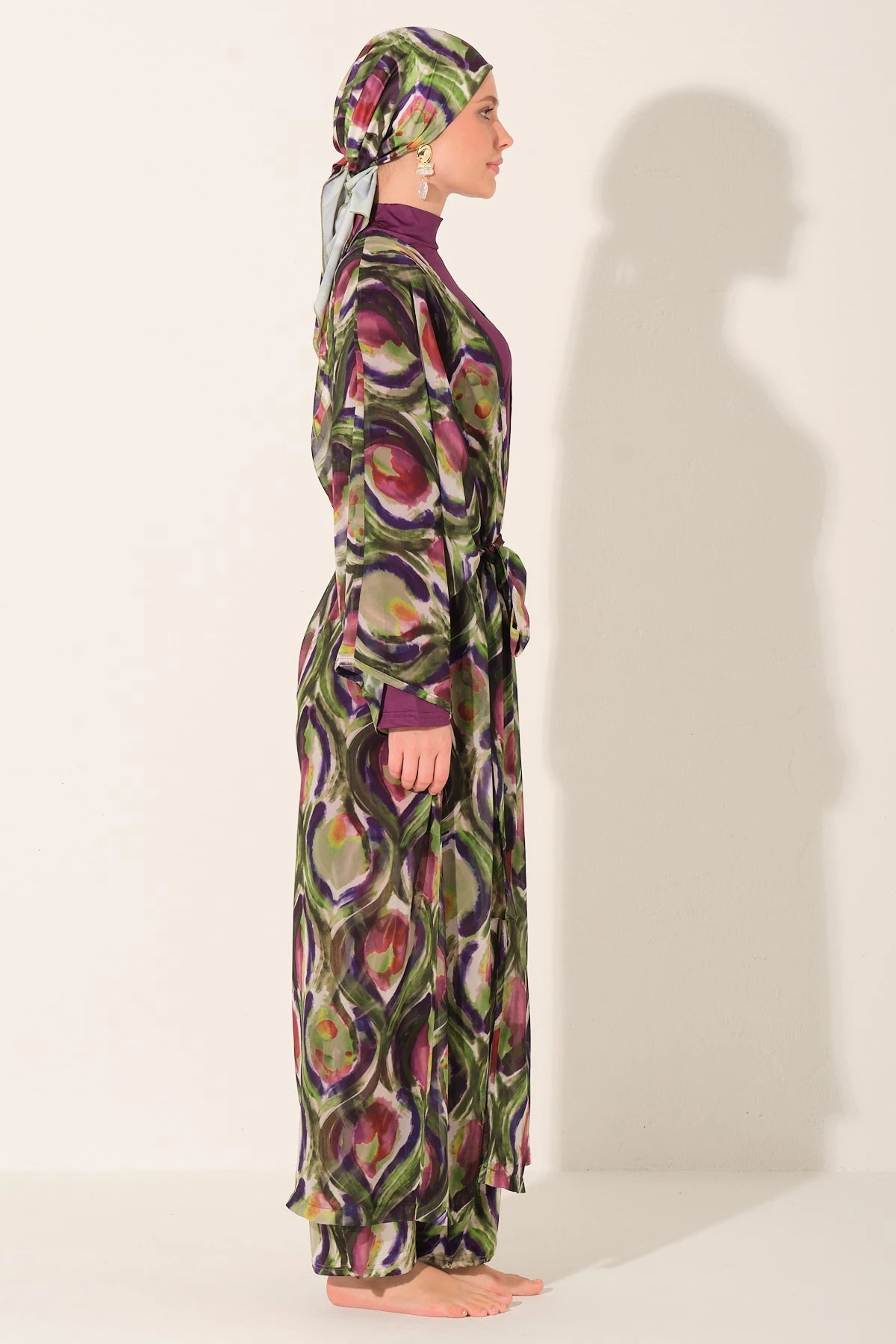 Side view of model wearing peacock print burkini and flowing kimono.