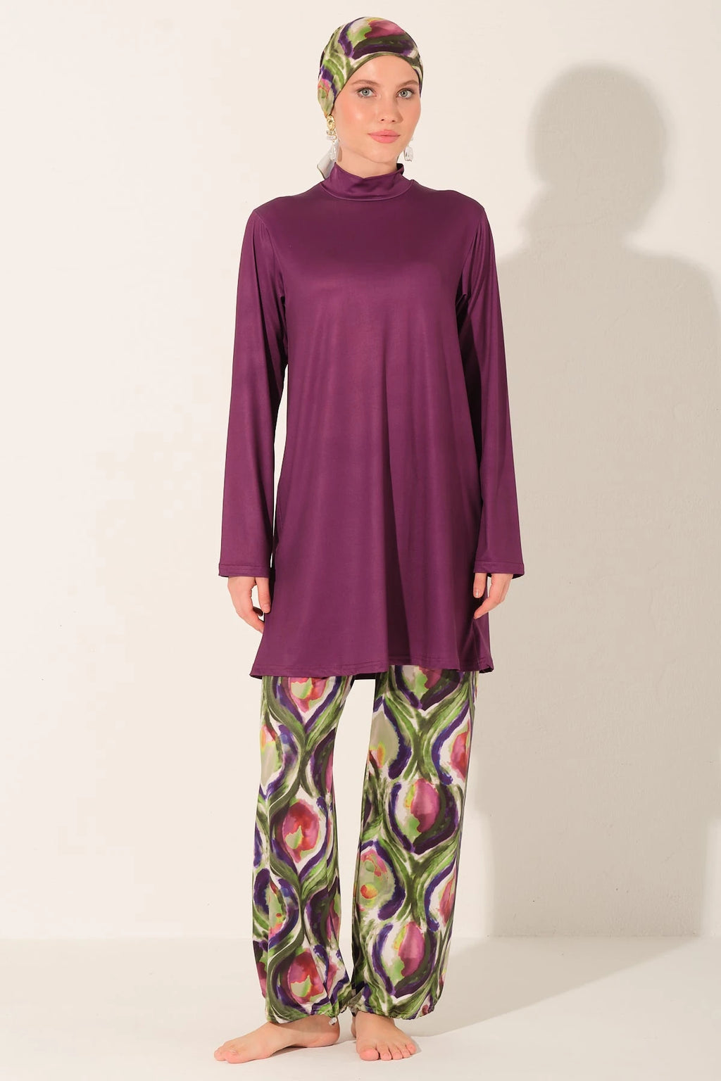 Front view of model in purple burkini top and printed swim pants.