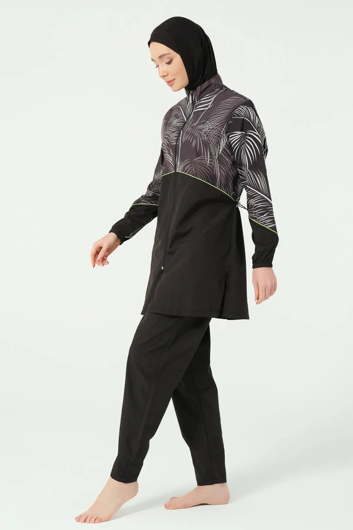 Modest black swimwear set with palm print top, walking side view.
