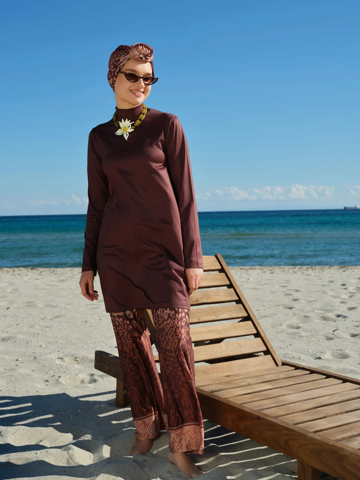Mocha print burkini with kimono on beach, model looking away.