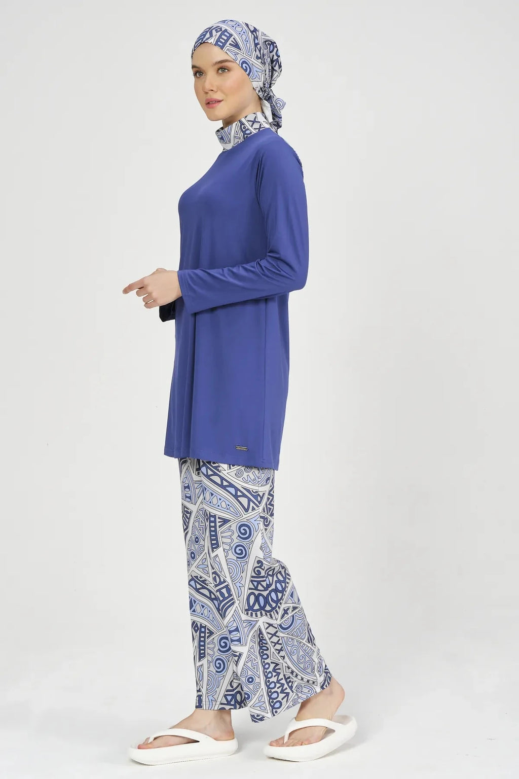 Side profile of model in blue Lycra burkini, walking pose.