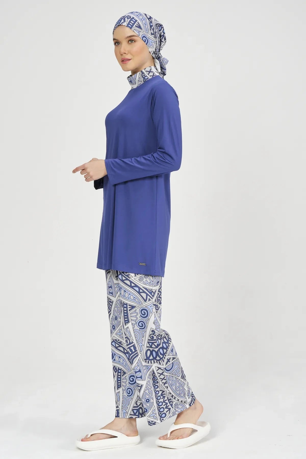 Side profile of model in blue Lycra burkini, walking pose.