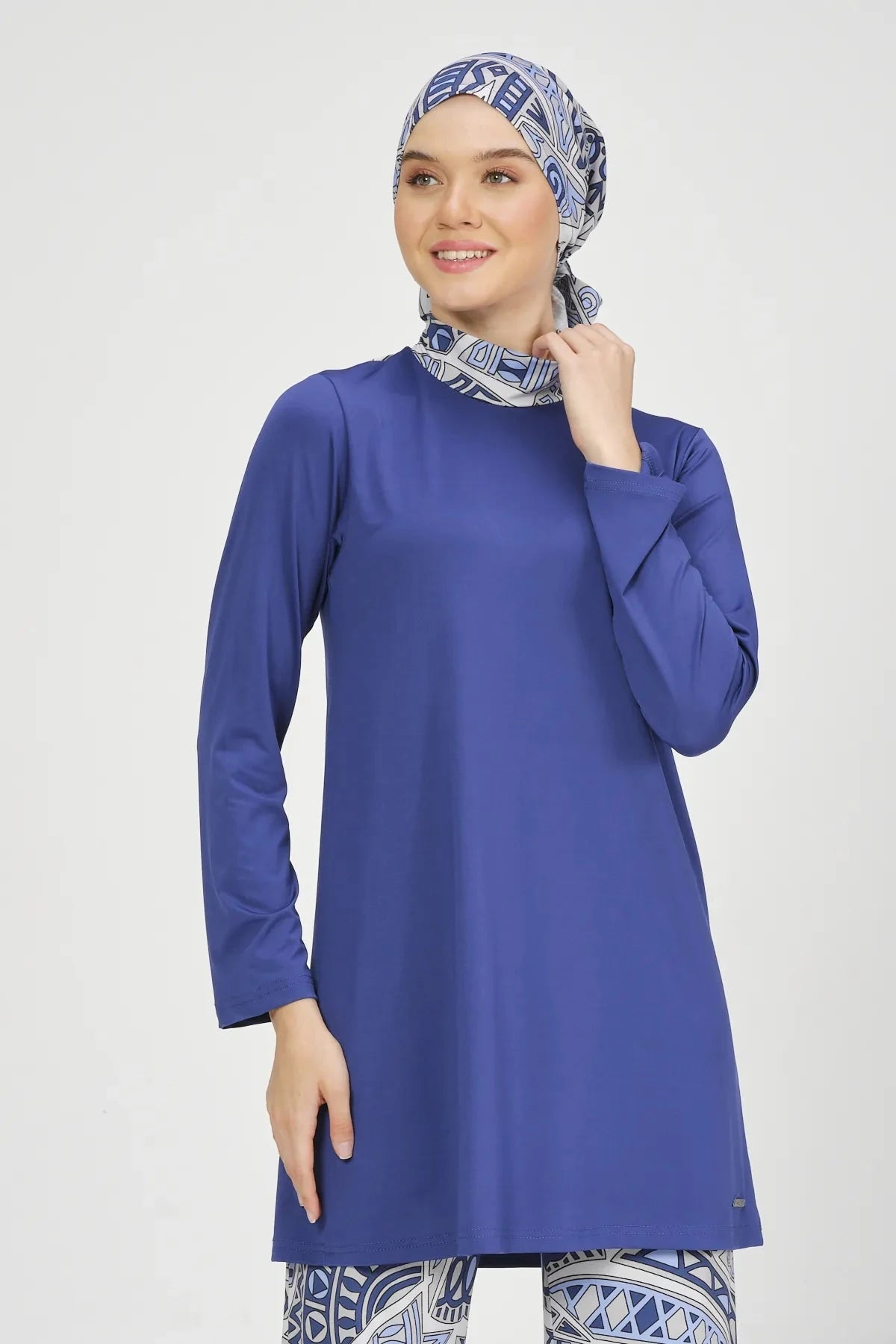 Close-up of model smiling in blue Lycra burkini top and hijab.