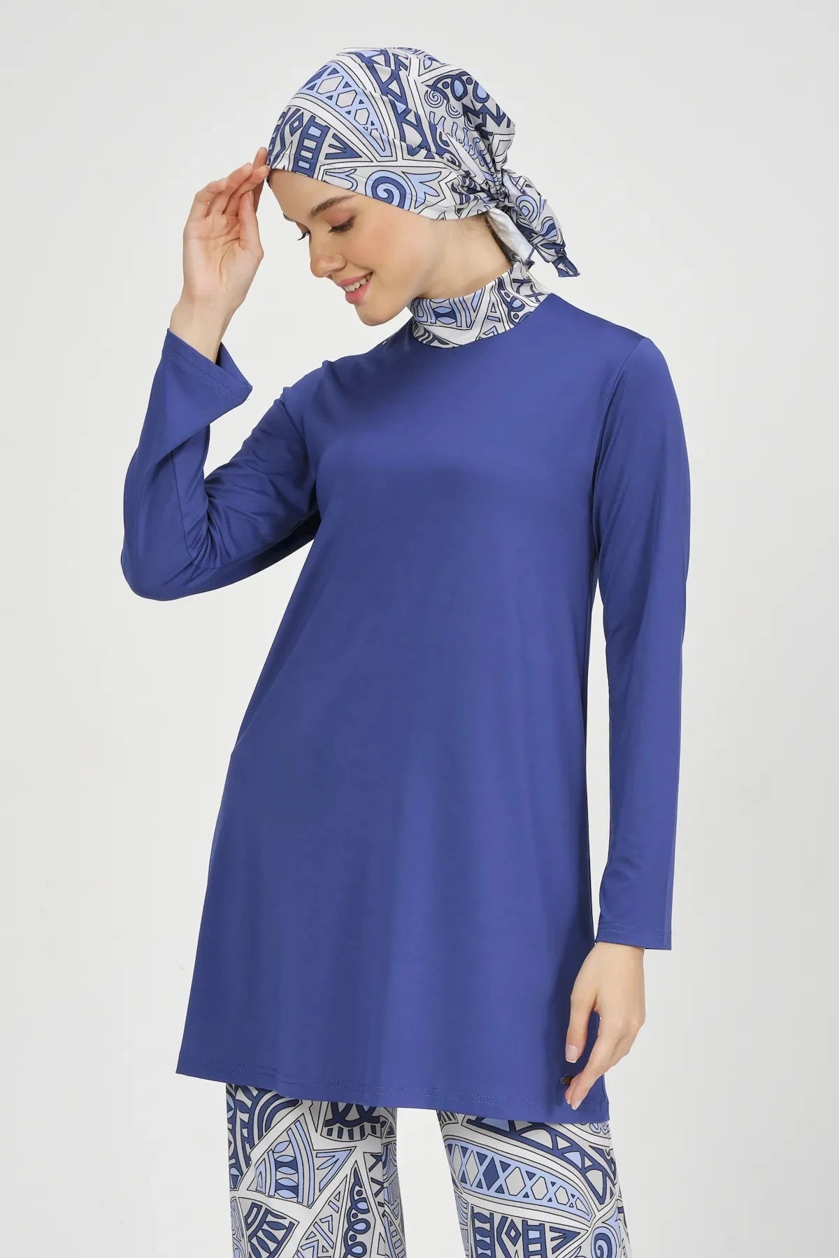 Model adjusting abstract print hijab of blue Lycra burkini.