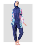 Model in tropical print burkini with navy blue panels, full front view.