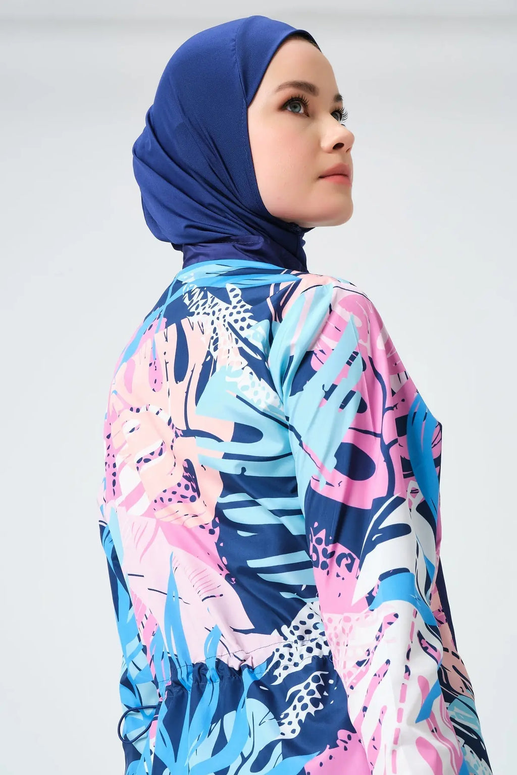 Close-up of model's face and navy hijab with tropical print burkini.
