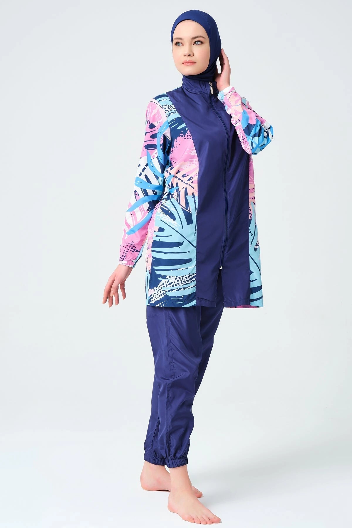 Model in tropical print burkini, full body shot, standing angled.