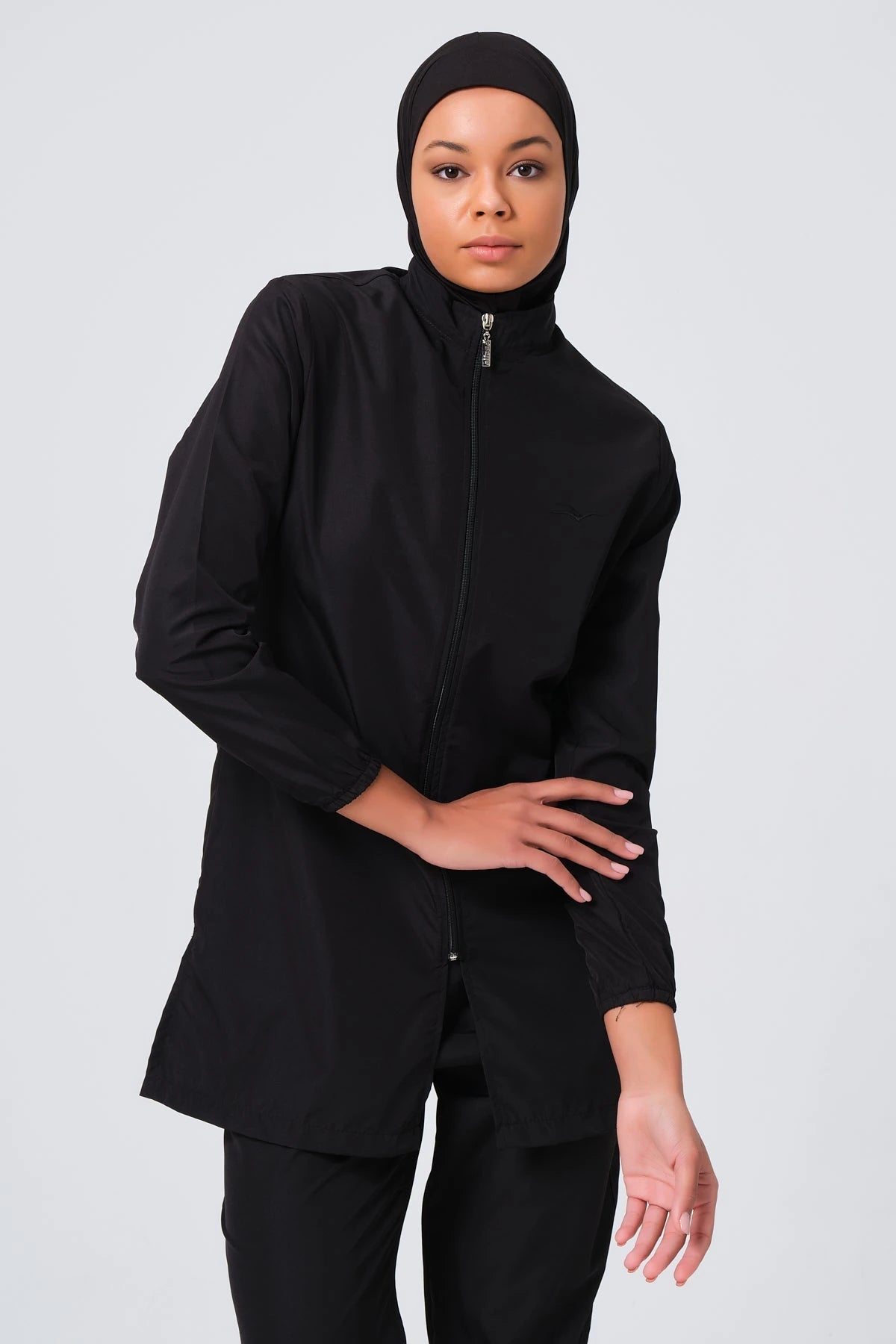 Model wearing black burkini tunic with high neck and zipper detail.