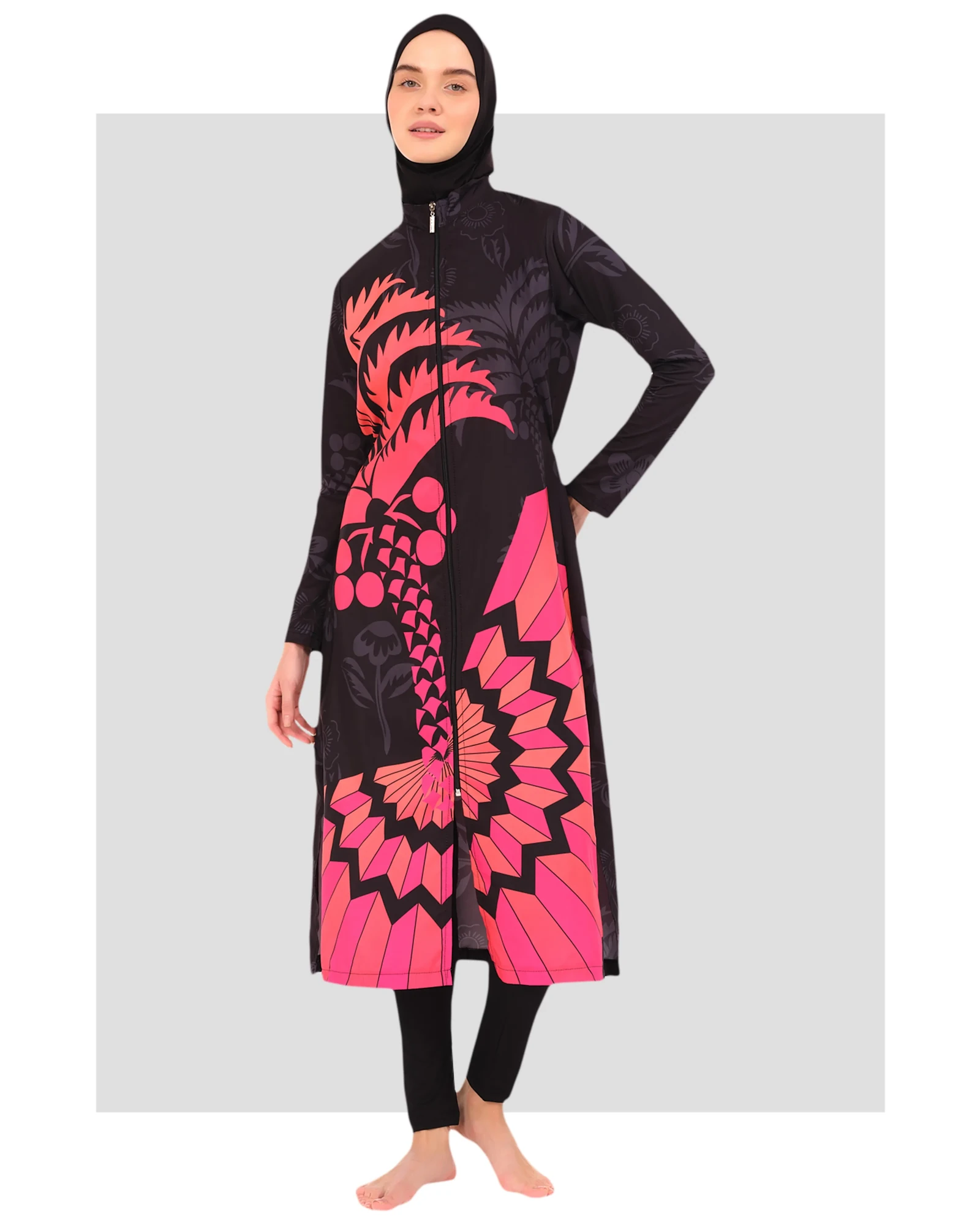 Woman wearing a fuchsia graphic print burkini with a front zipper and hijab.