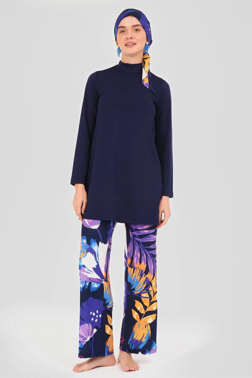 Navy long-sleeve tunic with floral swim pants, standing pose.