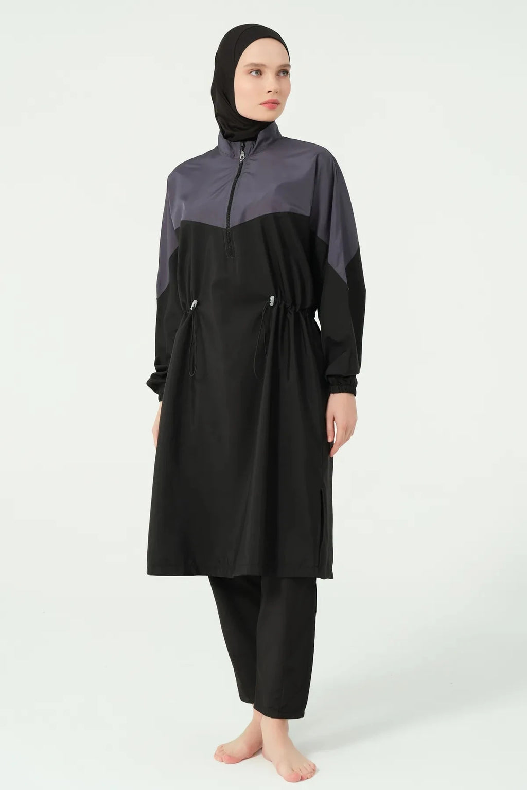 Full view of a woman in a monochrome burkini set with adjustable waist.