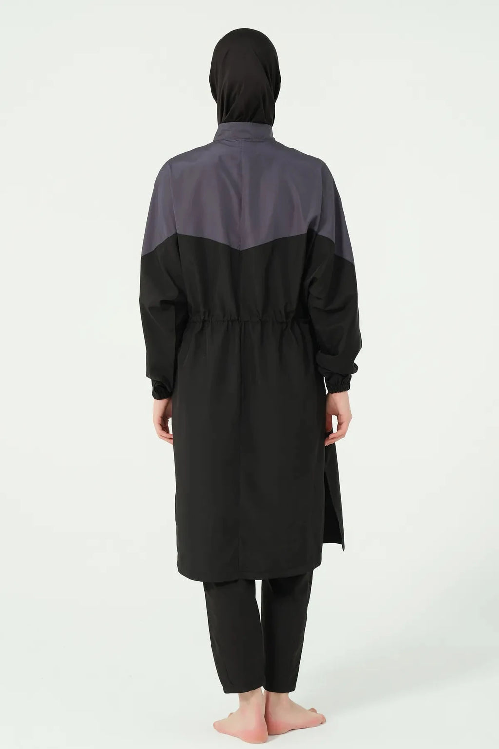 Back view of a woman in a monochrome burkini set with a long tunic.