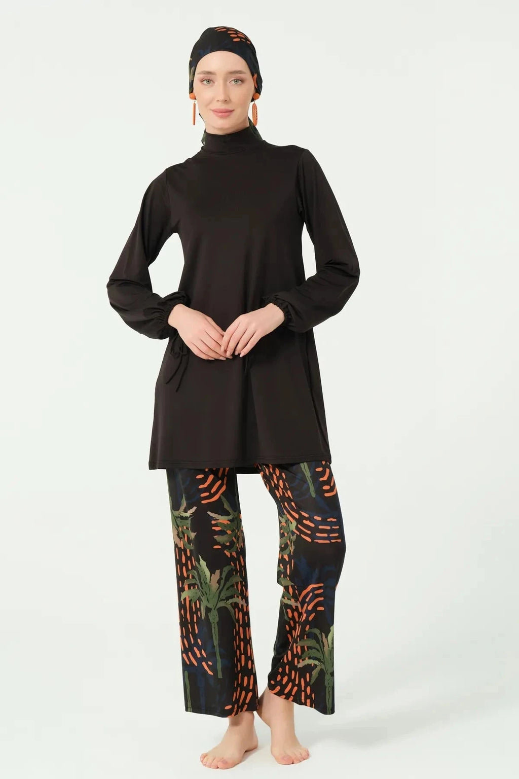 Full-coverage black burkini with tropical print pants and matching head covering.