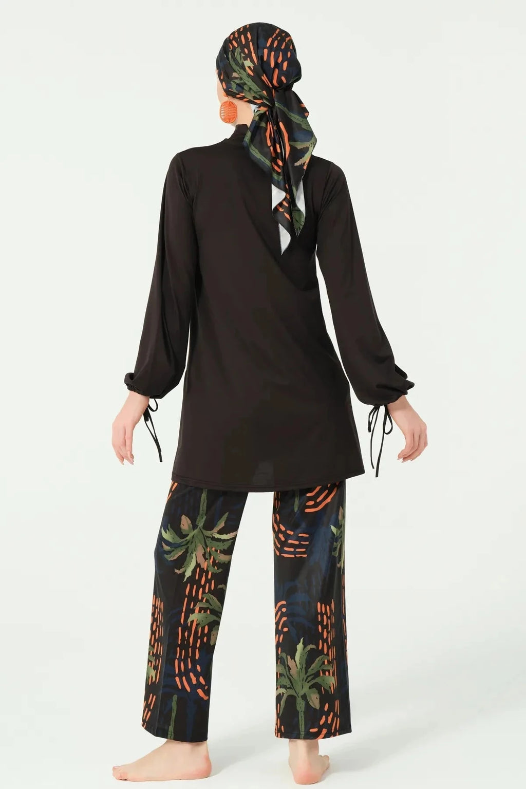 Back view of black burkini set with tropical palm print pants.