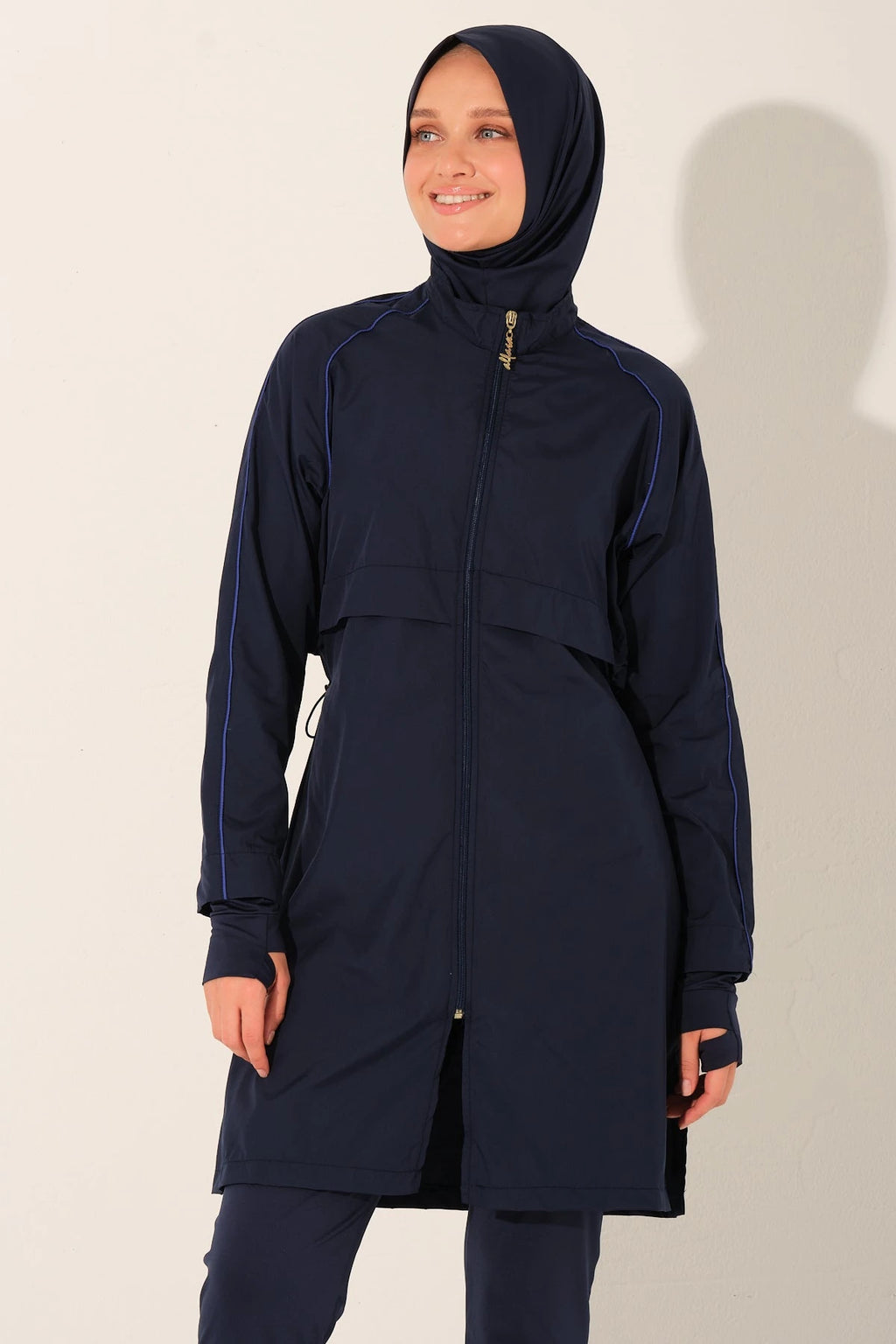 Smiling model in navy burkini set showing top and hijab.
