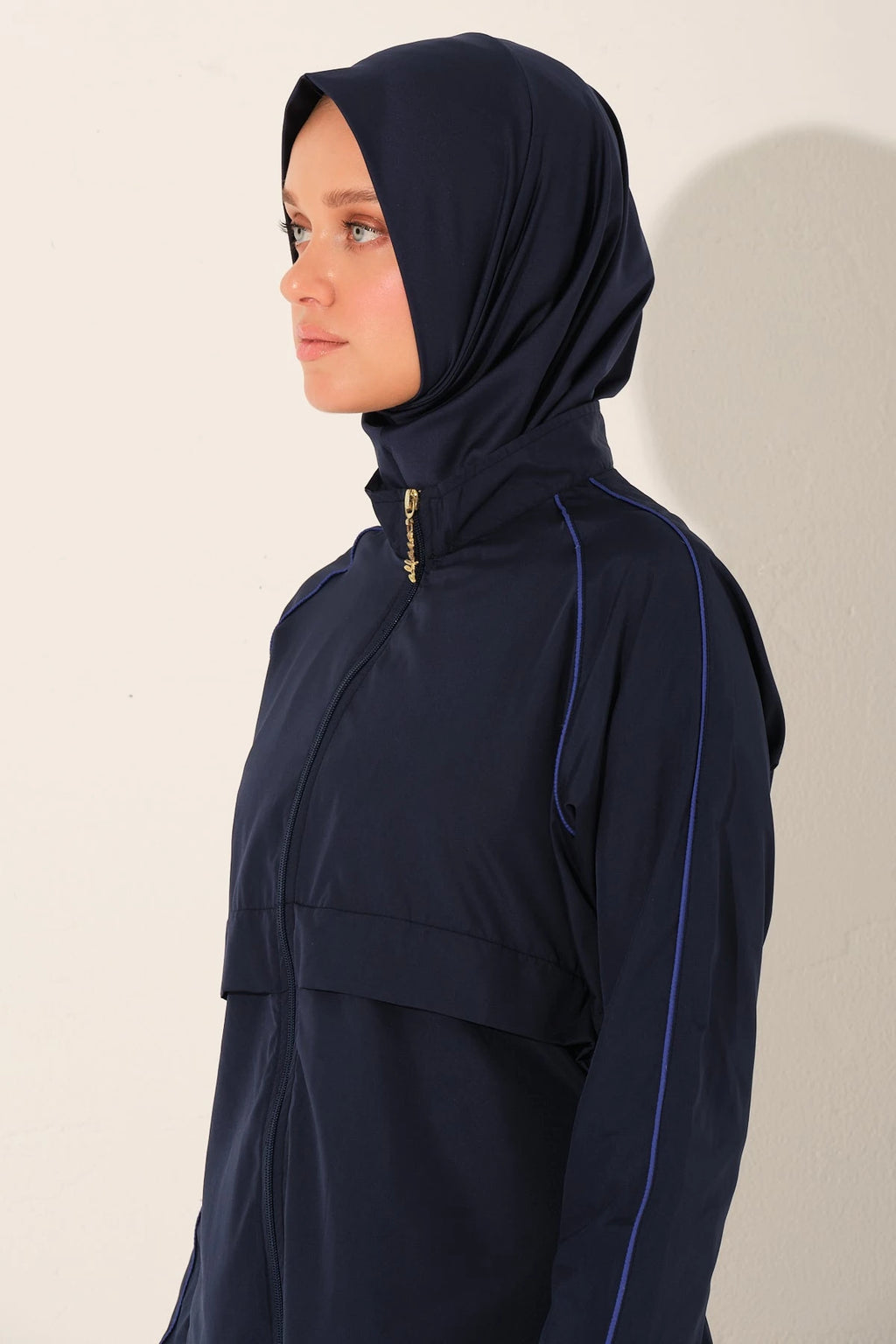 Side profile of navy burkini top with hijab and zipper detail.