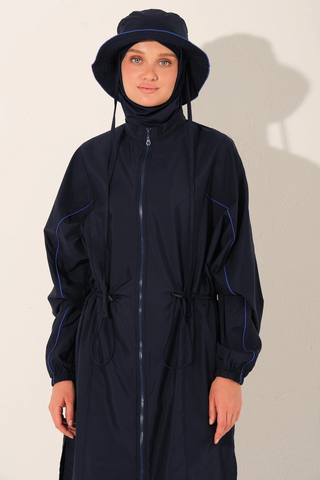 Close-up of model's face and navy burkini top with hat.