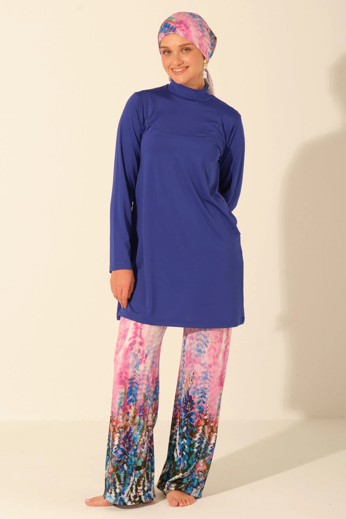 Front view of model in royal blue burkini top and printed swim pants.