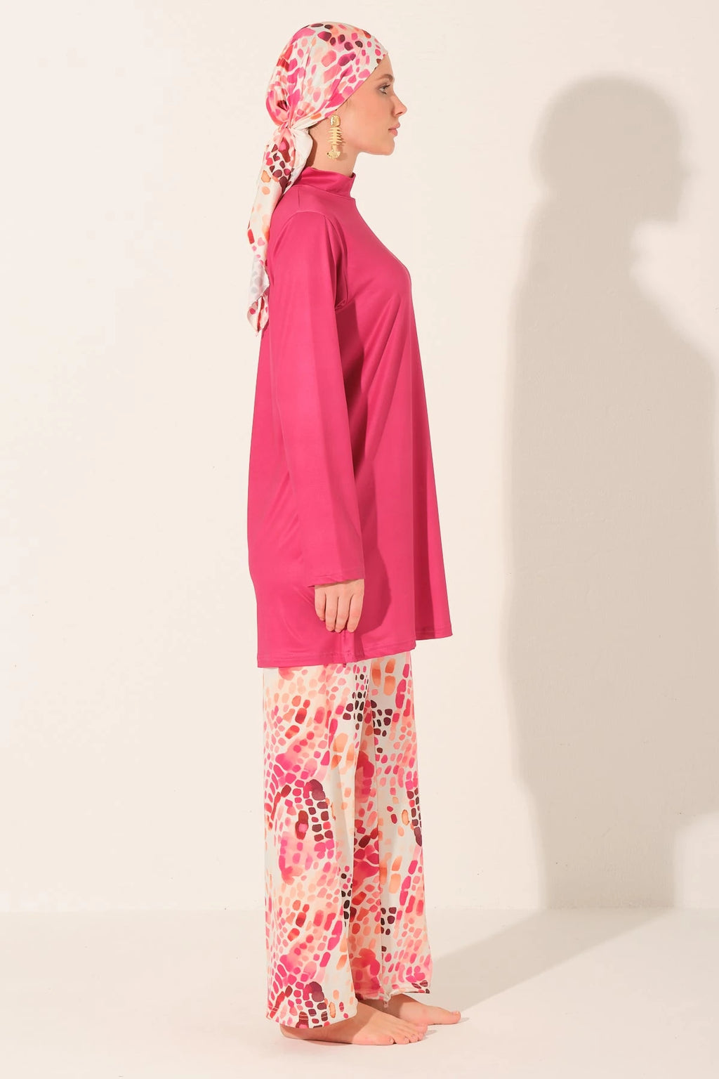 Fuchsia burkini set with patterned pants and scarf, side profile.
