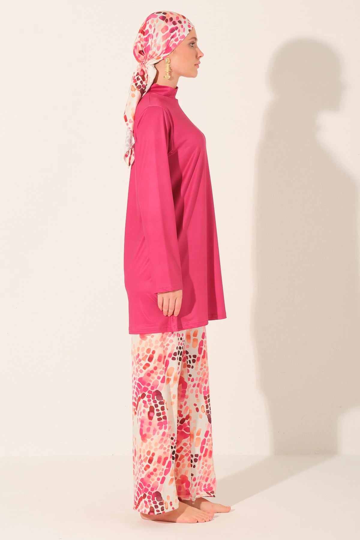 Fuchsia burkini set with patterned pants and scarf, side profile.