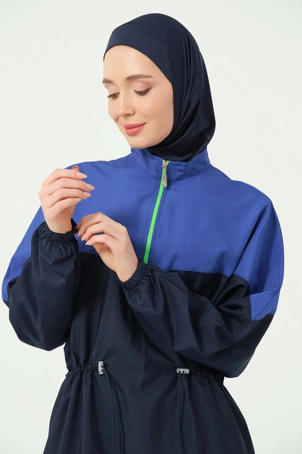 Model adjusting navy blue and royal blue burkini sleeve cuff.