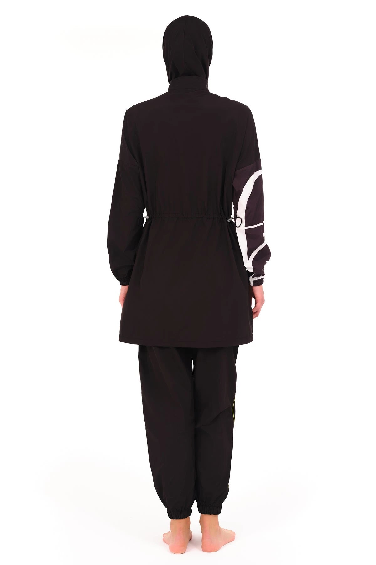 Woman wearing black burkini with white geometric print on sleeve back view.