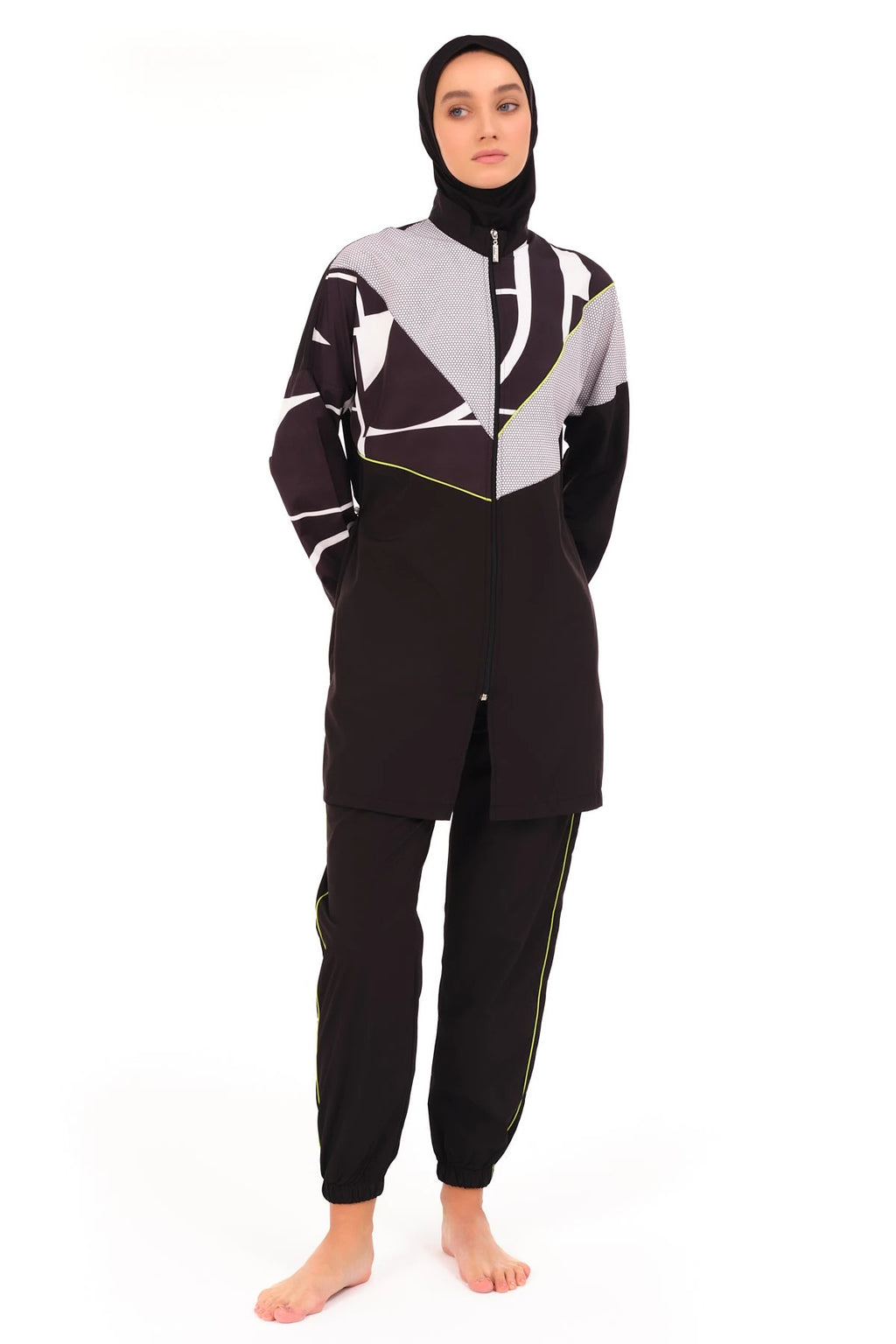 Woman in black and grey geometric print burkini with hands in pockets.