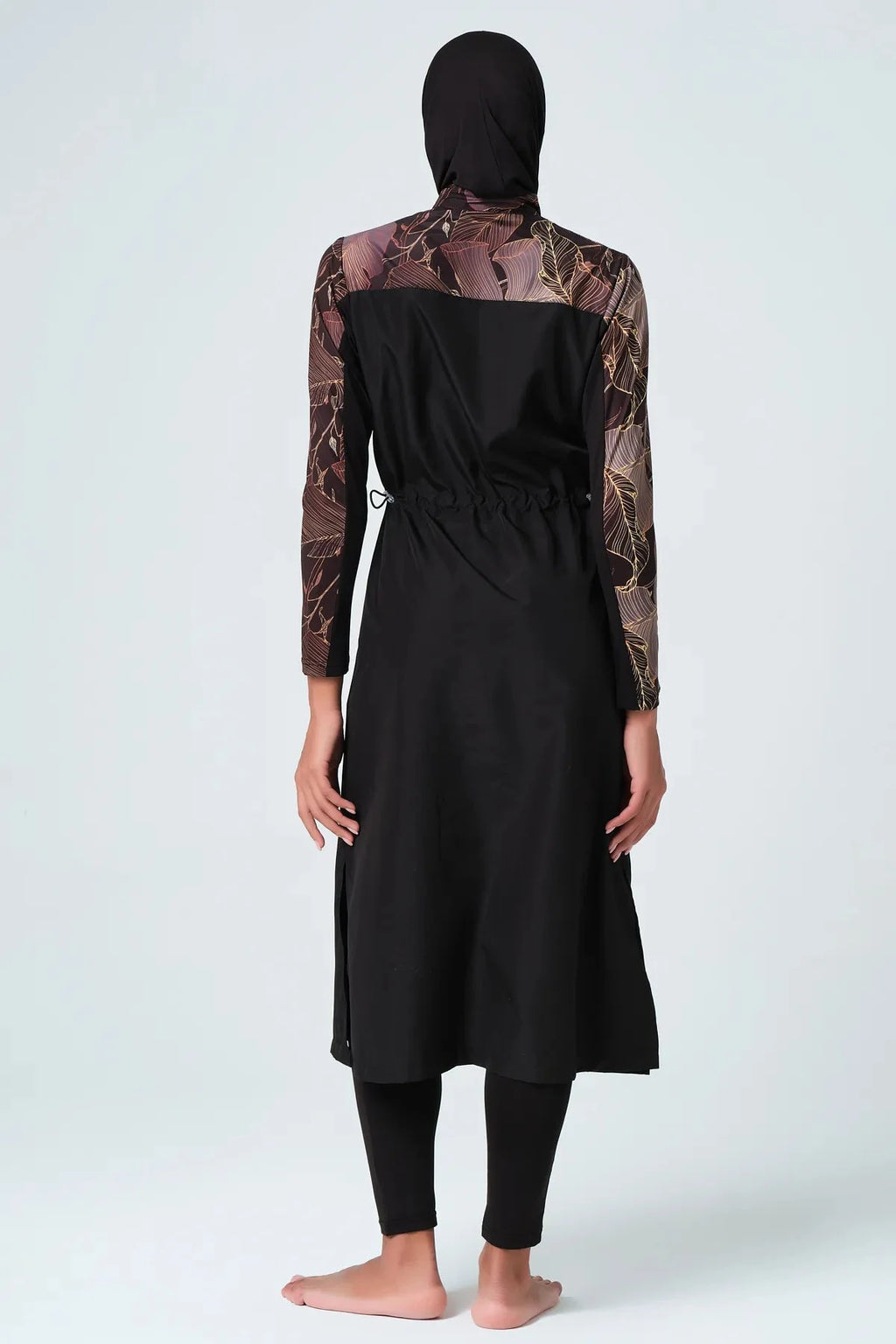 Back view of black burkini with patterned sleeves and adjustable waist.
