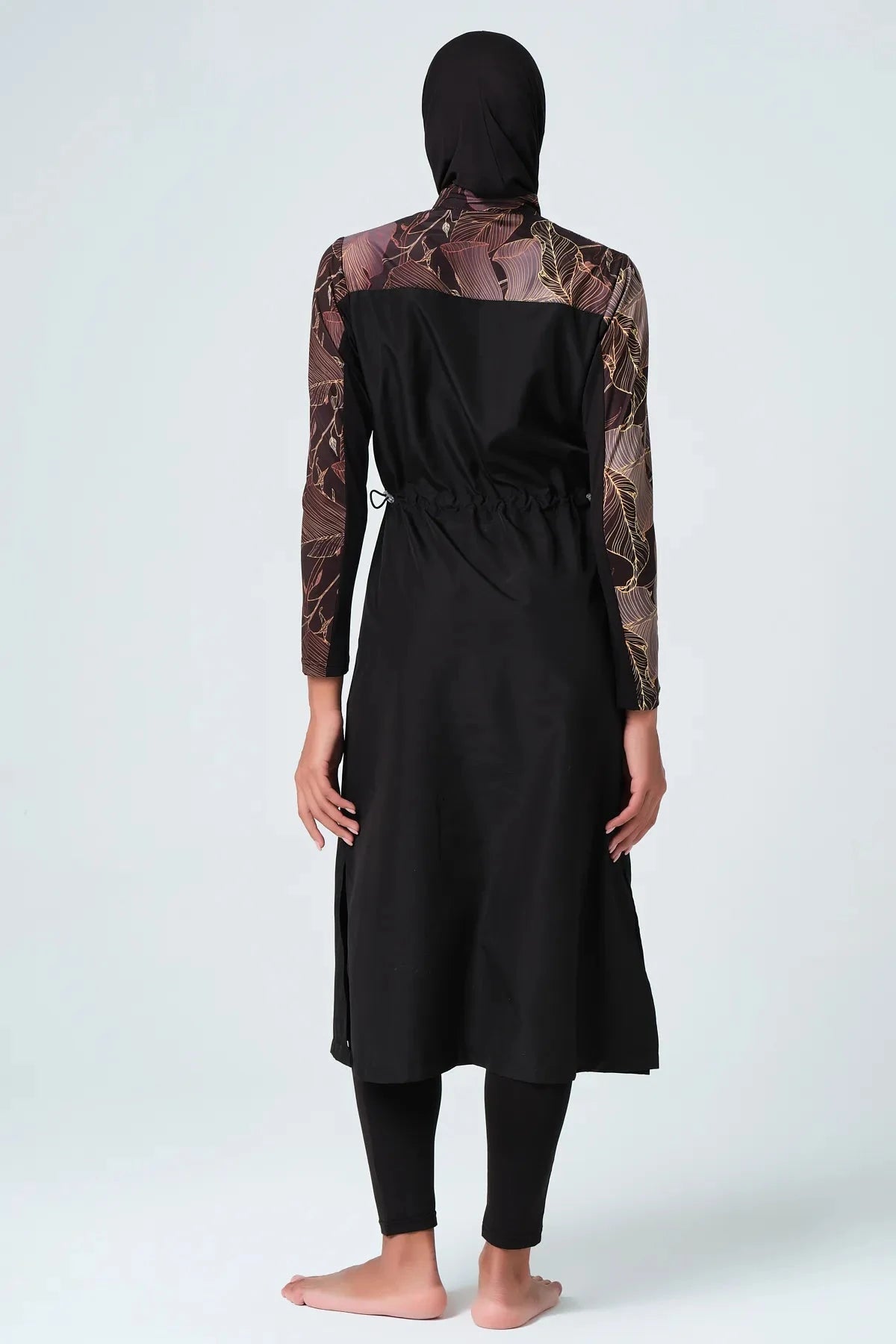 Back view of black burkini with patterned sleeves and adjustable waist.
