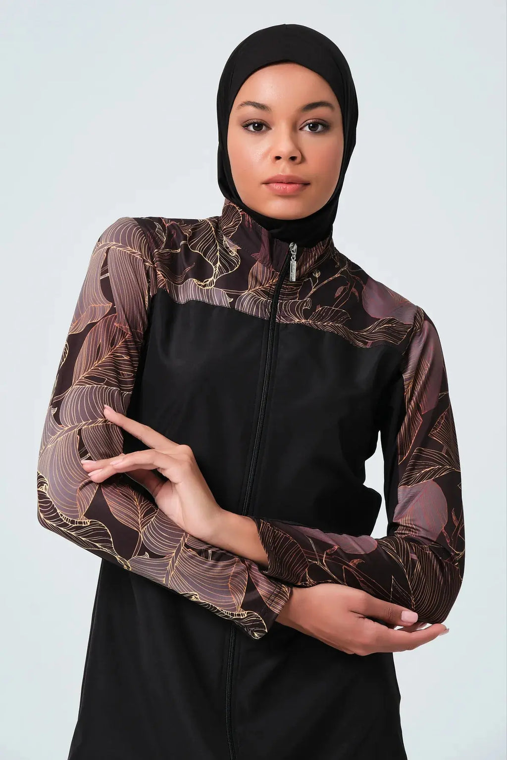 Close-up of black burkini with patterned sleeves and zipper detail.