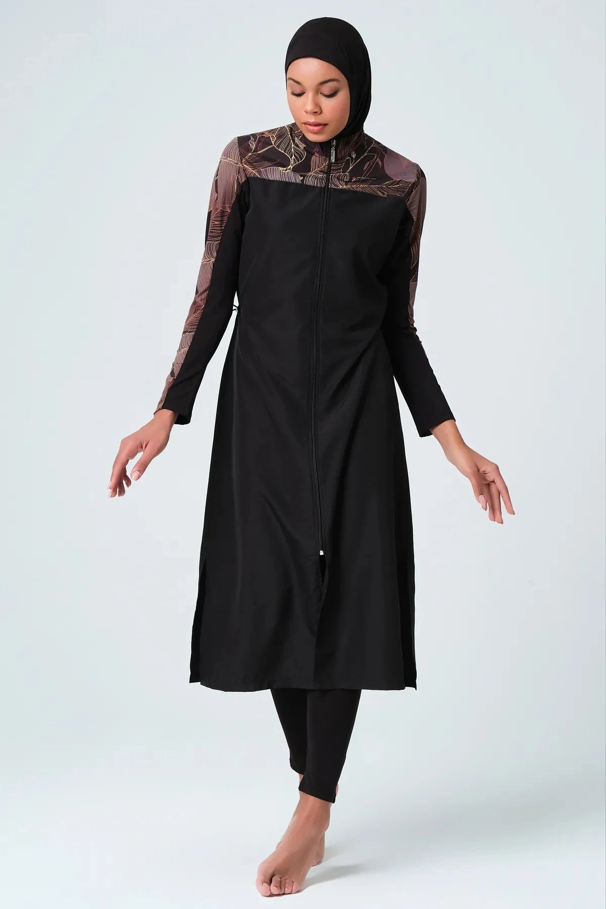 Full body shot of black burkini with patterned sleeves and hijab.