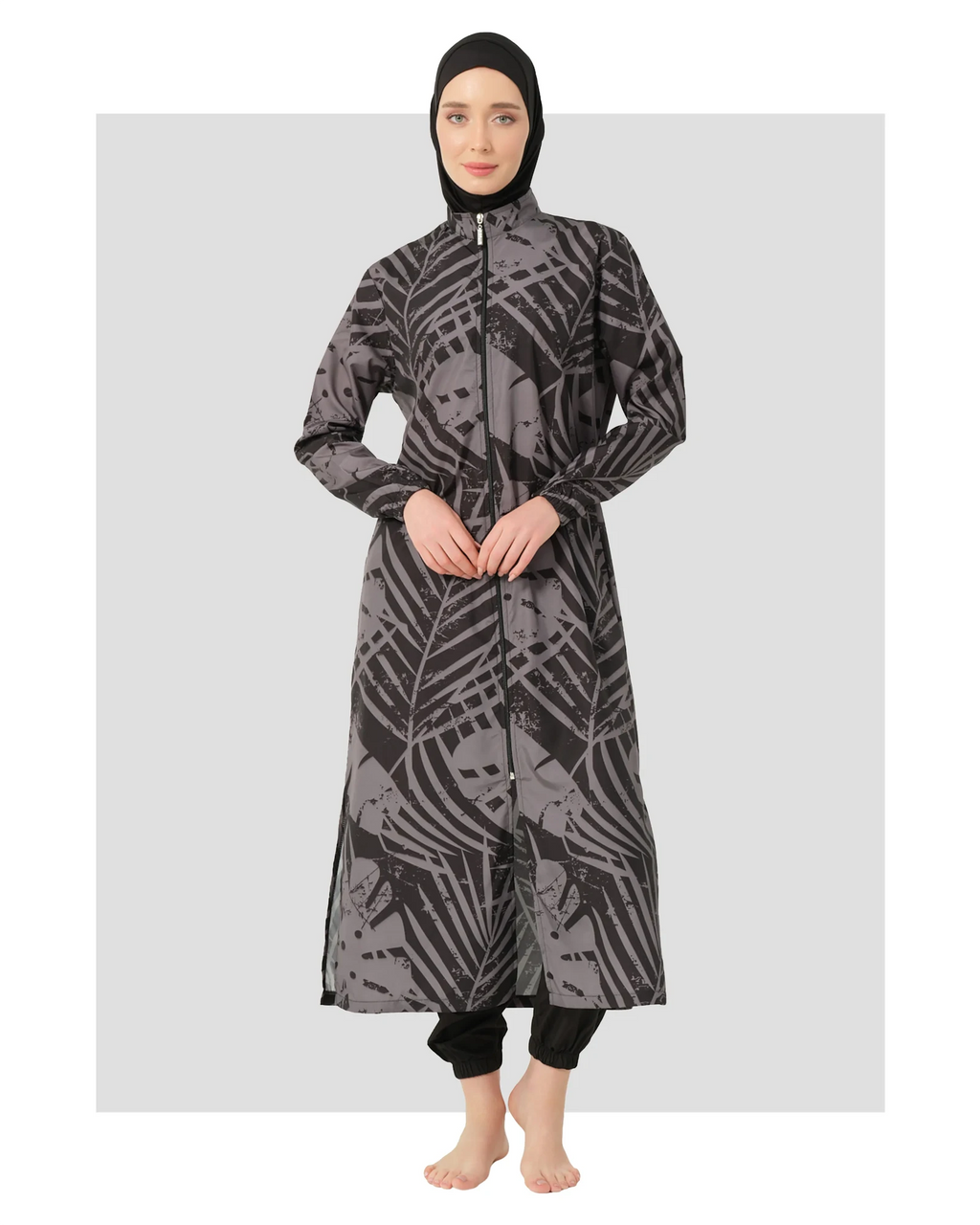 Woman wearing a black and grey abstract print burkini with a hijab.