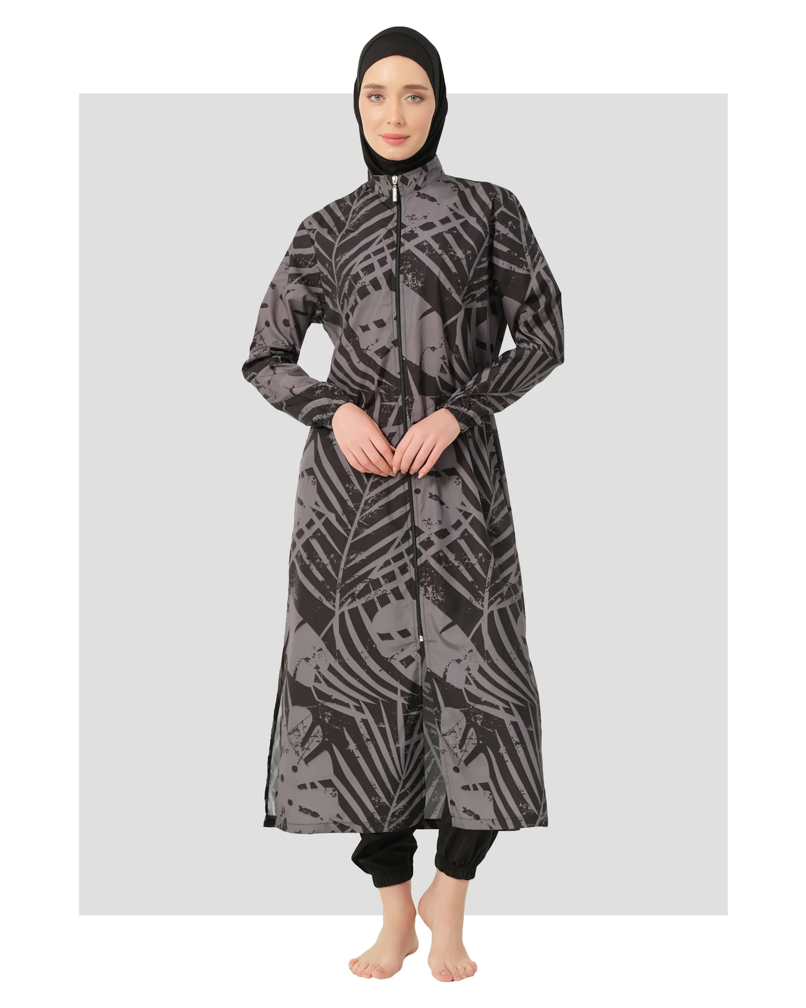 Woman wearing a black and grey abstract print burkini with a hijab.