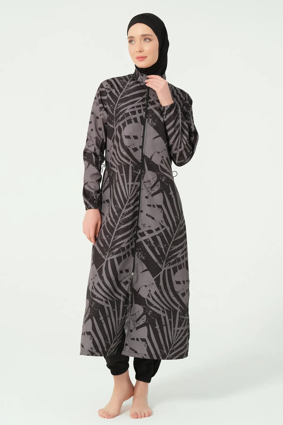 Woman in a black and grey abstract print burkini, showing zipper detail.