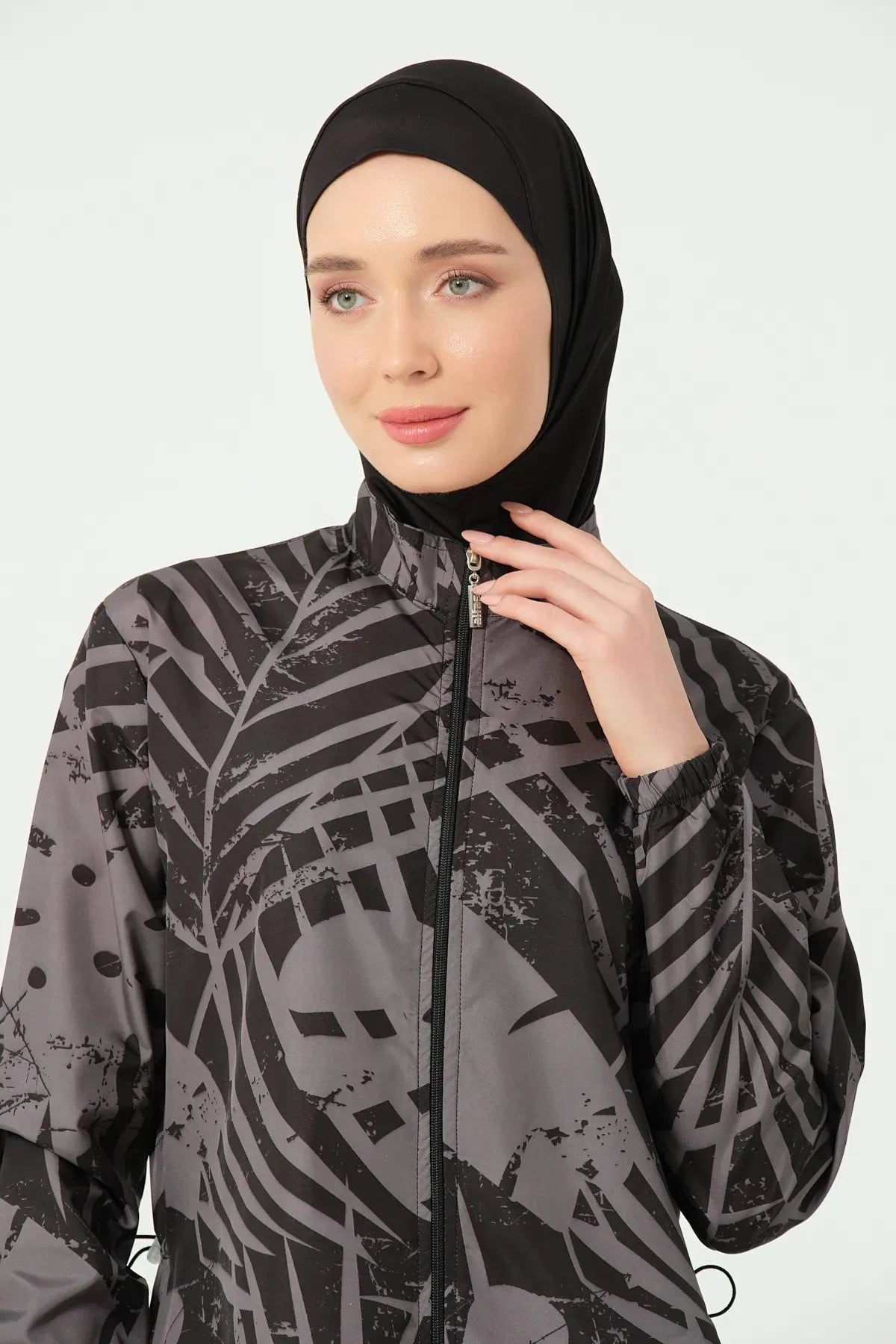 Woman's face and upper chest wearing a black and grey abstract print burkini.