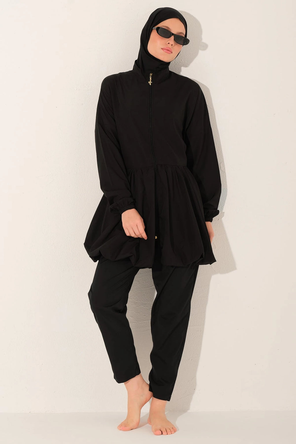 Full coverage black modest swimwear on model, front pose.