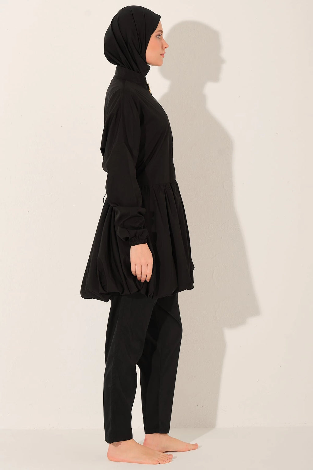 Black burkini swimsuit with hijab cap, side view.