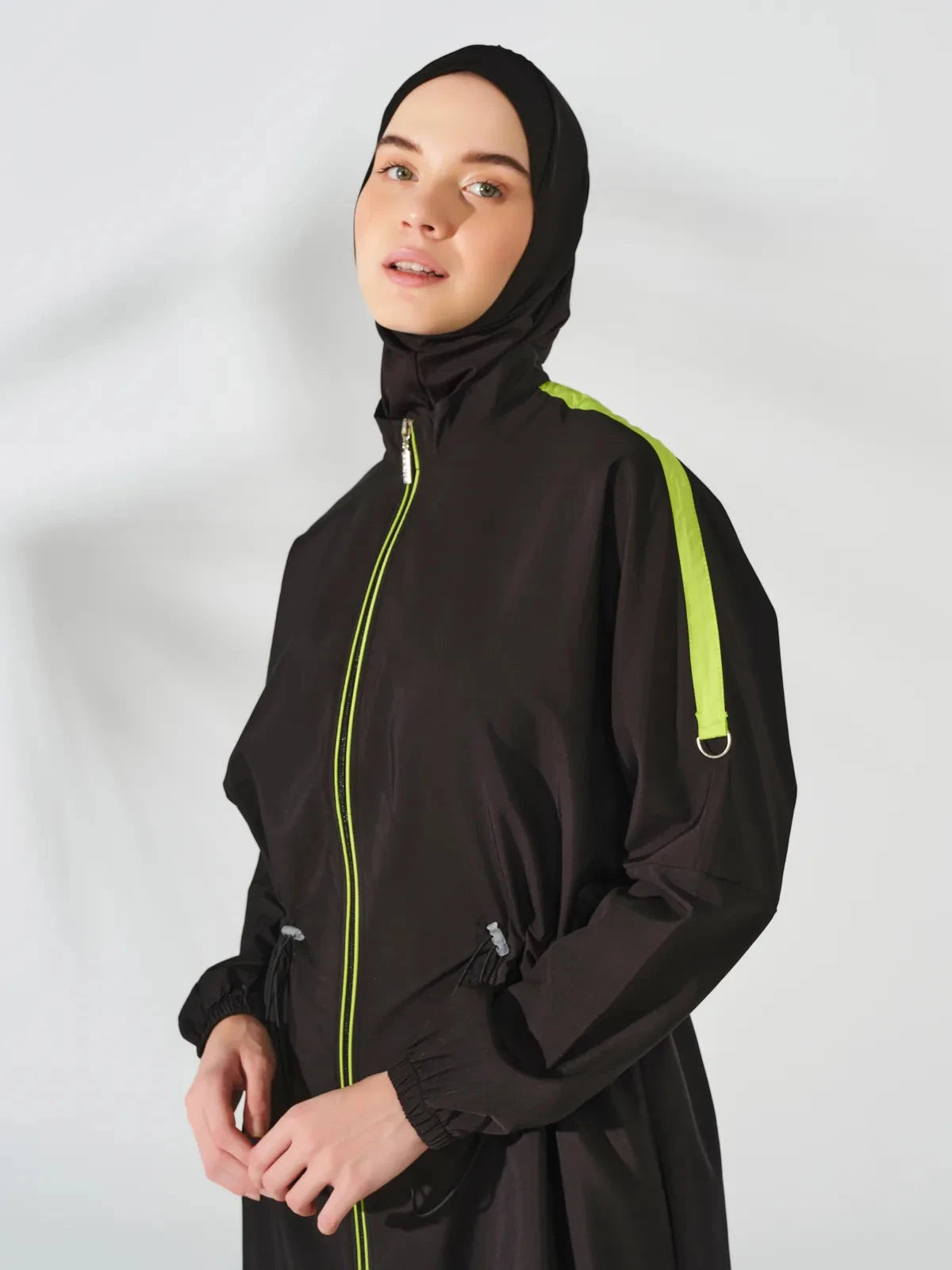 Close-up of black burkini jacket with neon green zipper and trim.