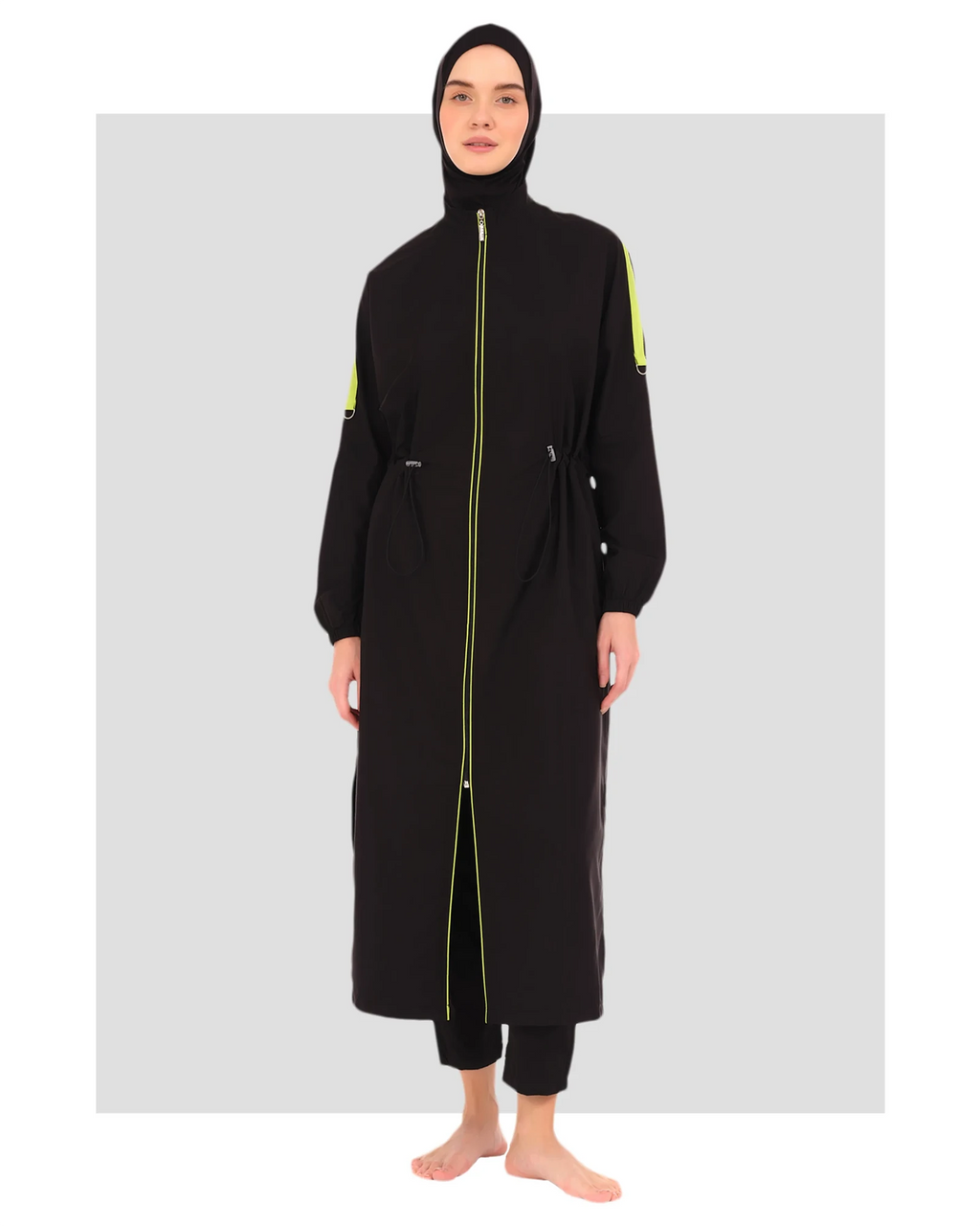 Full view of black burkini set with neon green accents on model.