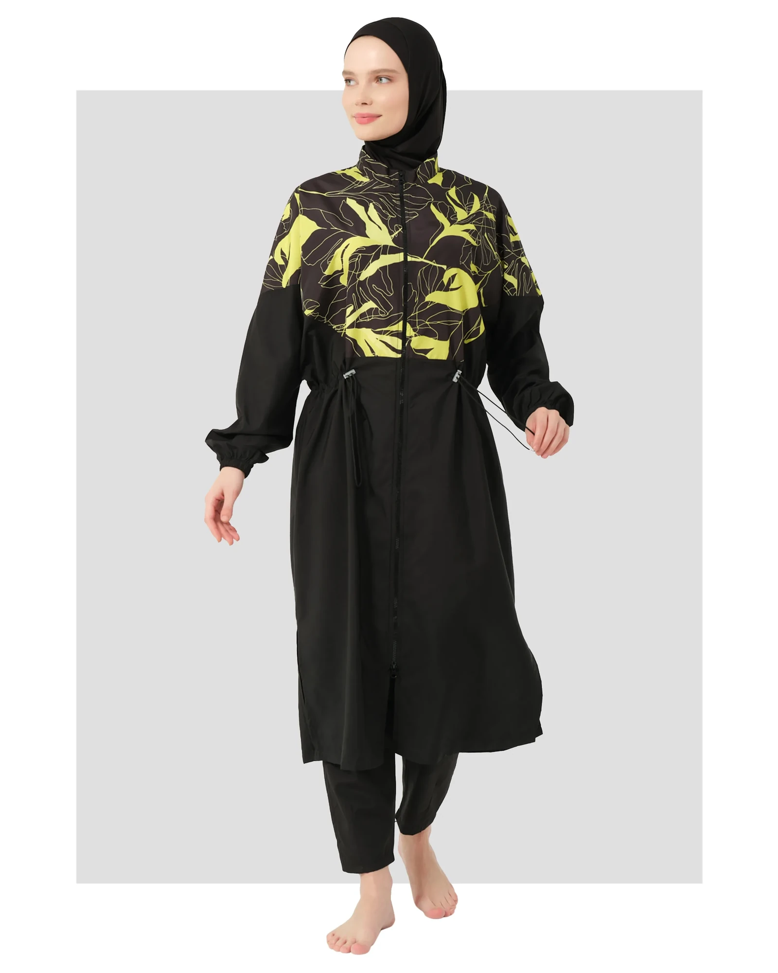 Woman wearing a black and yellow tropical print burkini set from the front.