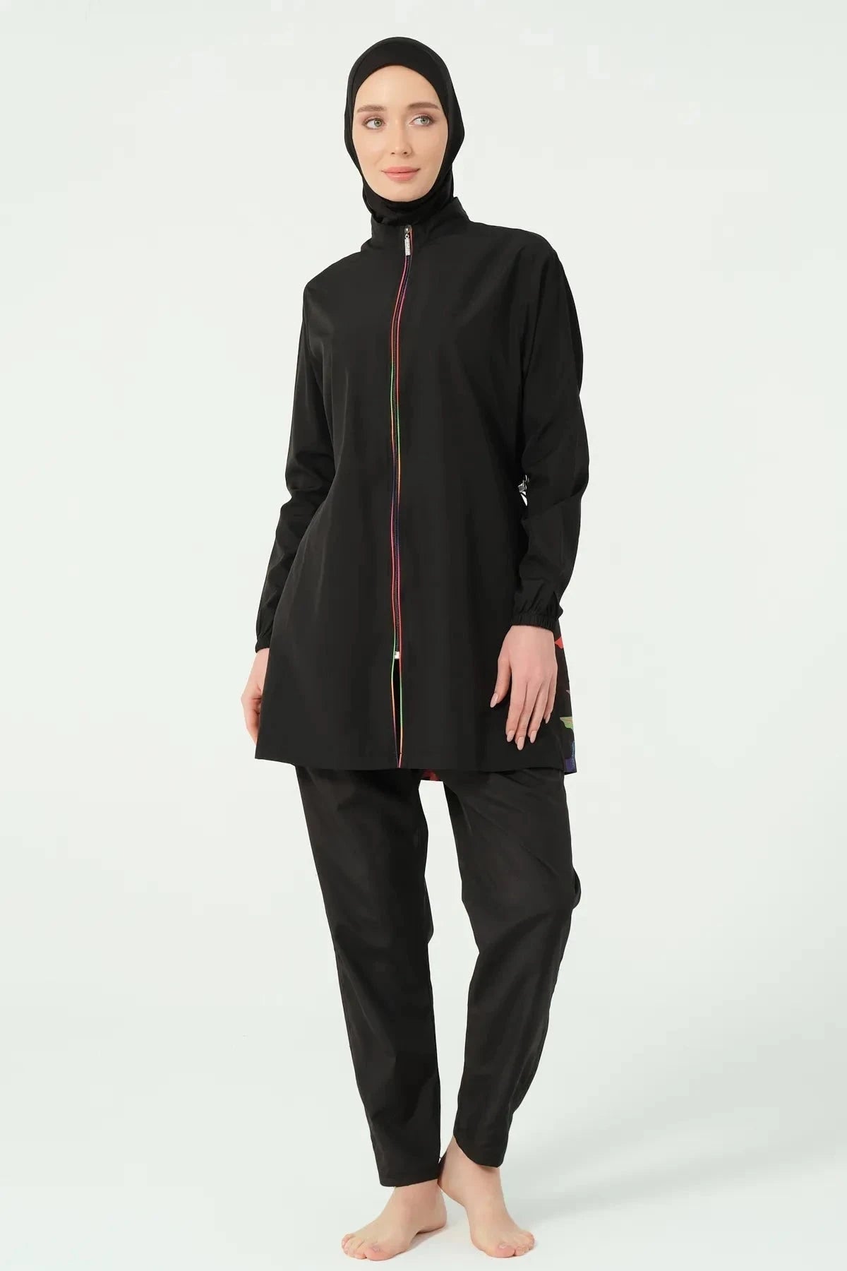 Model in black burkini with full zipper, front view on white background.