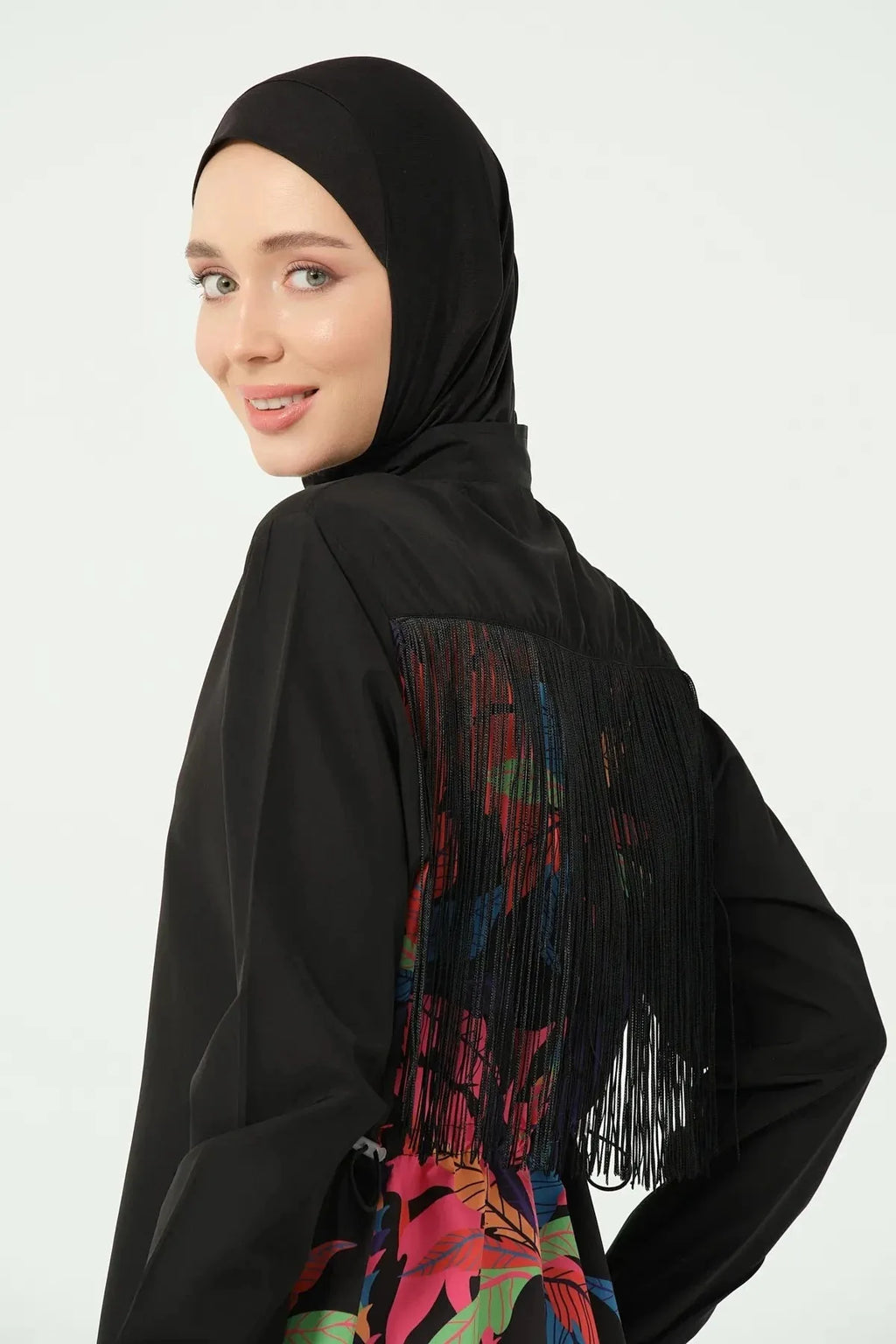 Close-up of model in black burkini with fringe detail and tropical print.