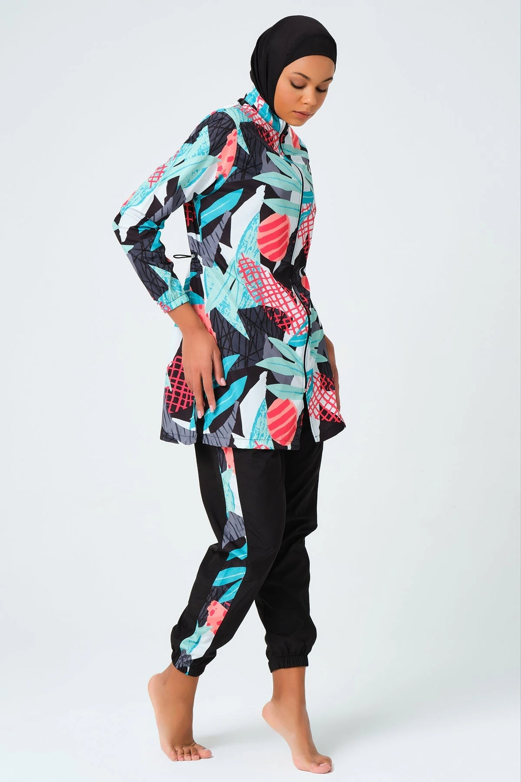 Woman in full coverage tropical print burkini set side view.