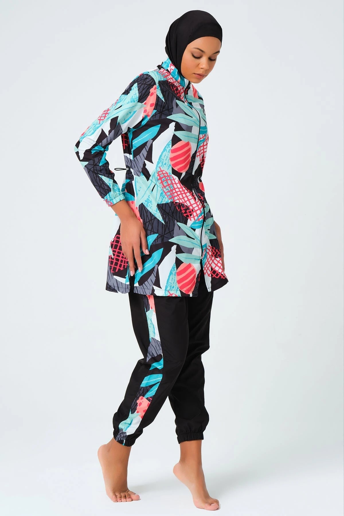 Woman in full coverage tropical print burkini set side view.