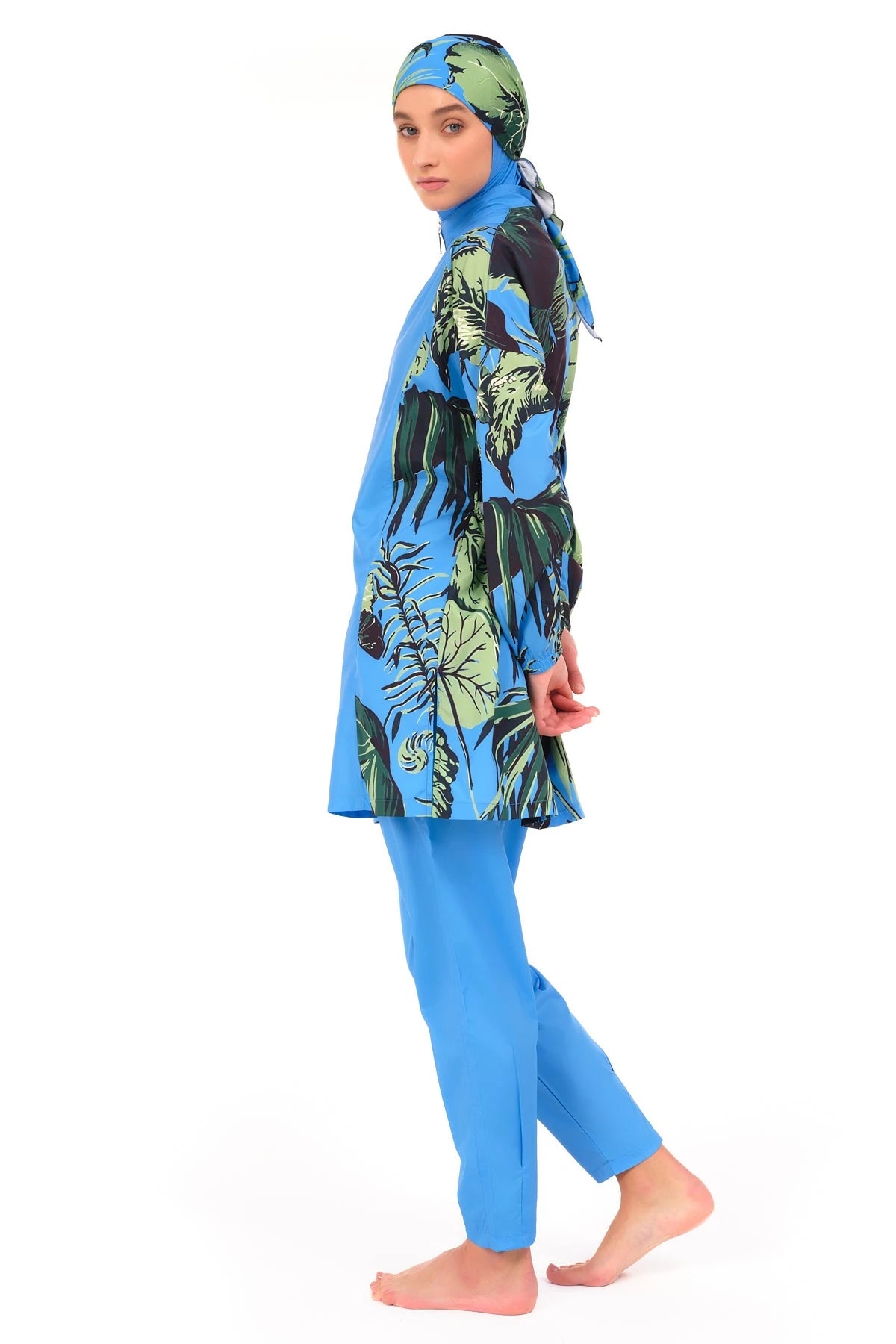 Blue burkini with tropical print sleeves and side panels, side view.