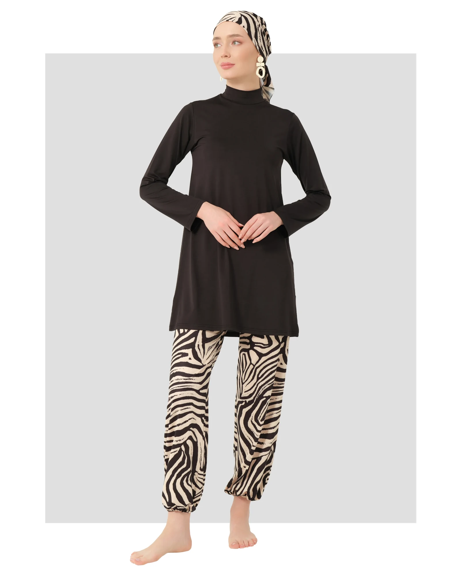 Woman in black burkini top and zebra print swim pants with matching headscarf.
