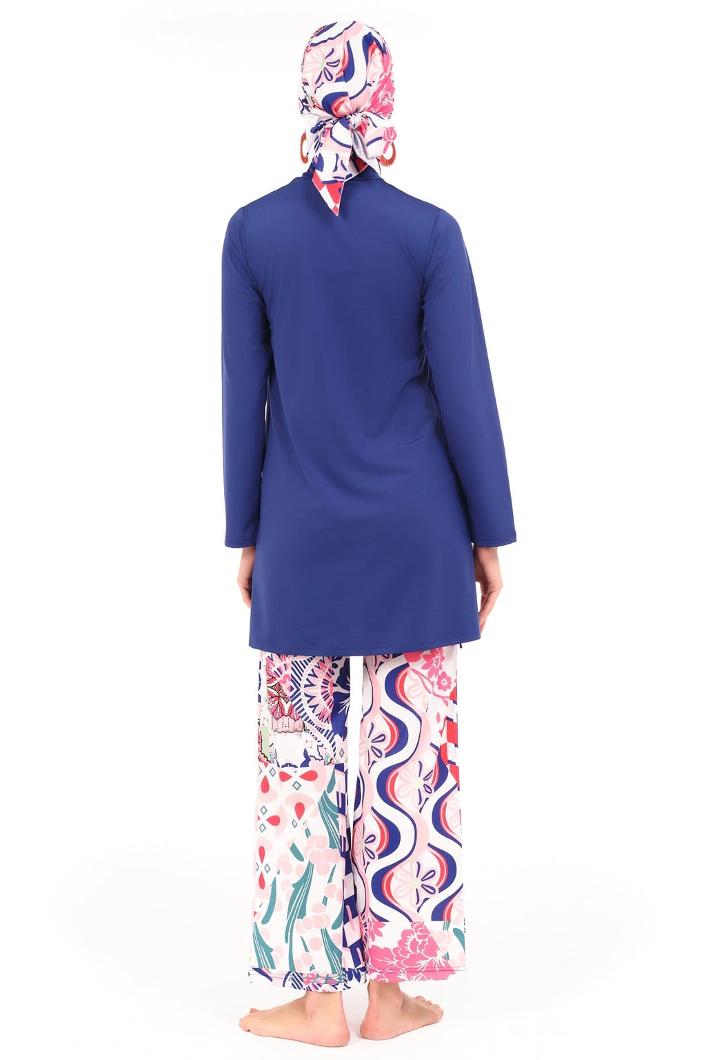 Model in blue and patterned burkini set, back view, standing on white background.